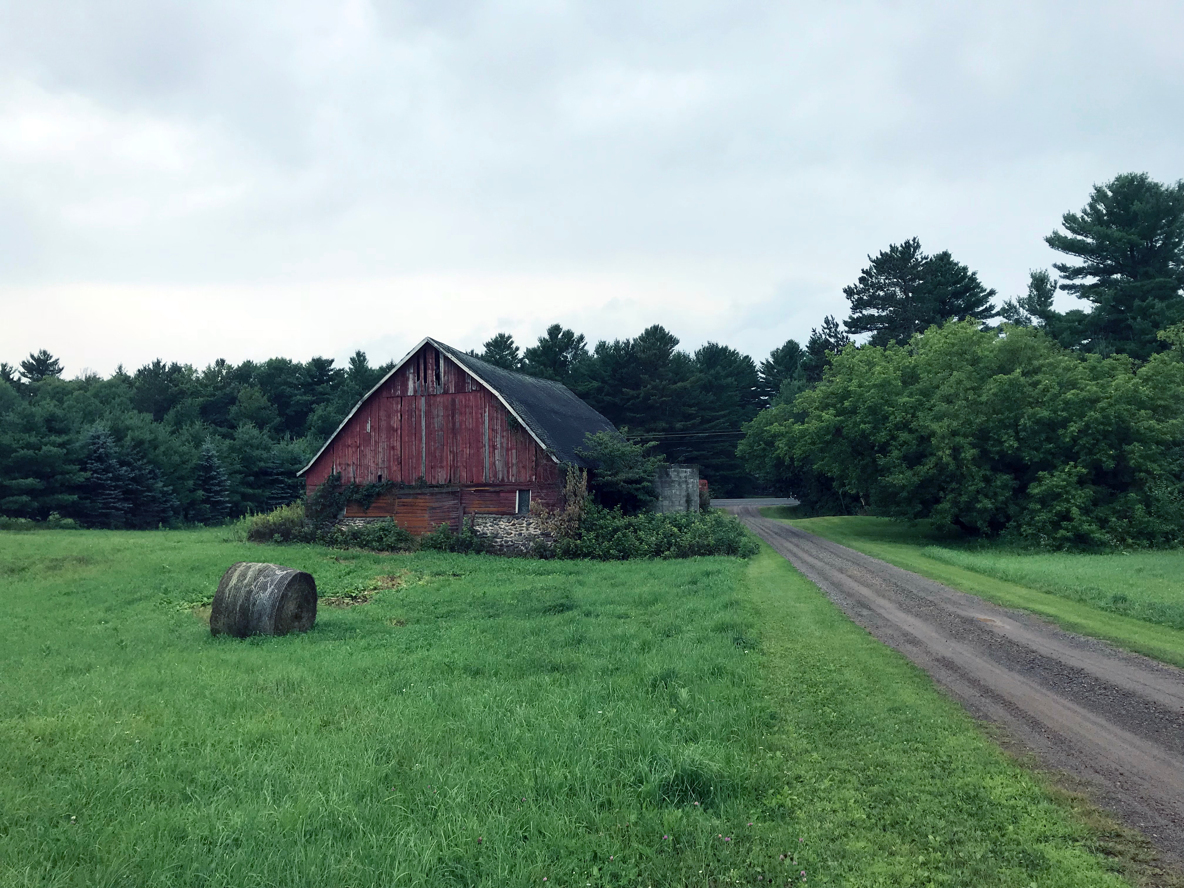 An old red barn along a dirt road.