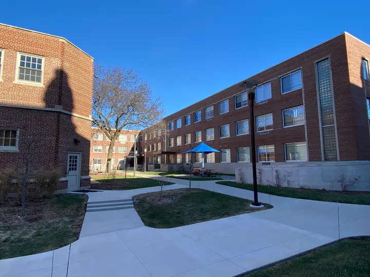 The 3 story L shaped brick building on a sunny winter day.