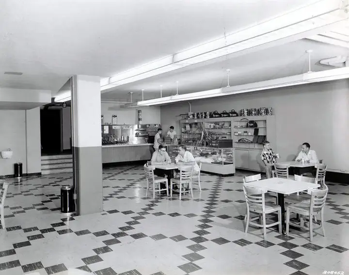 Small student lounge containing a few tables and a store counter in back.