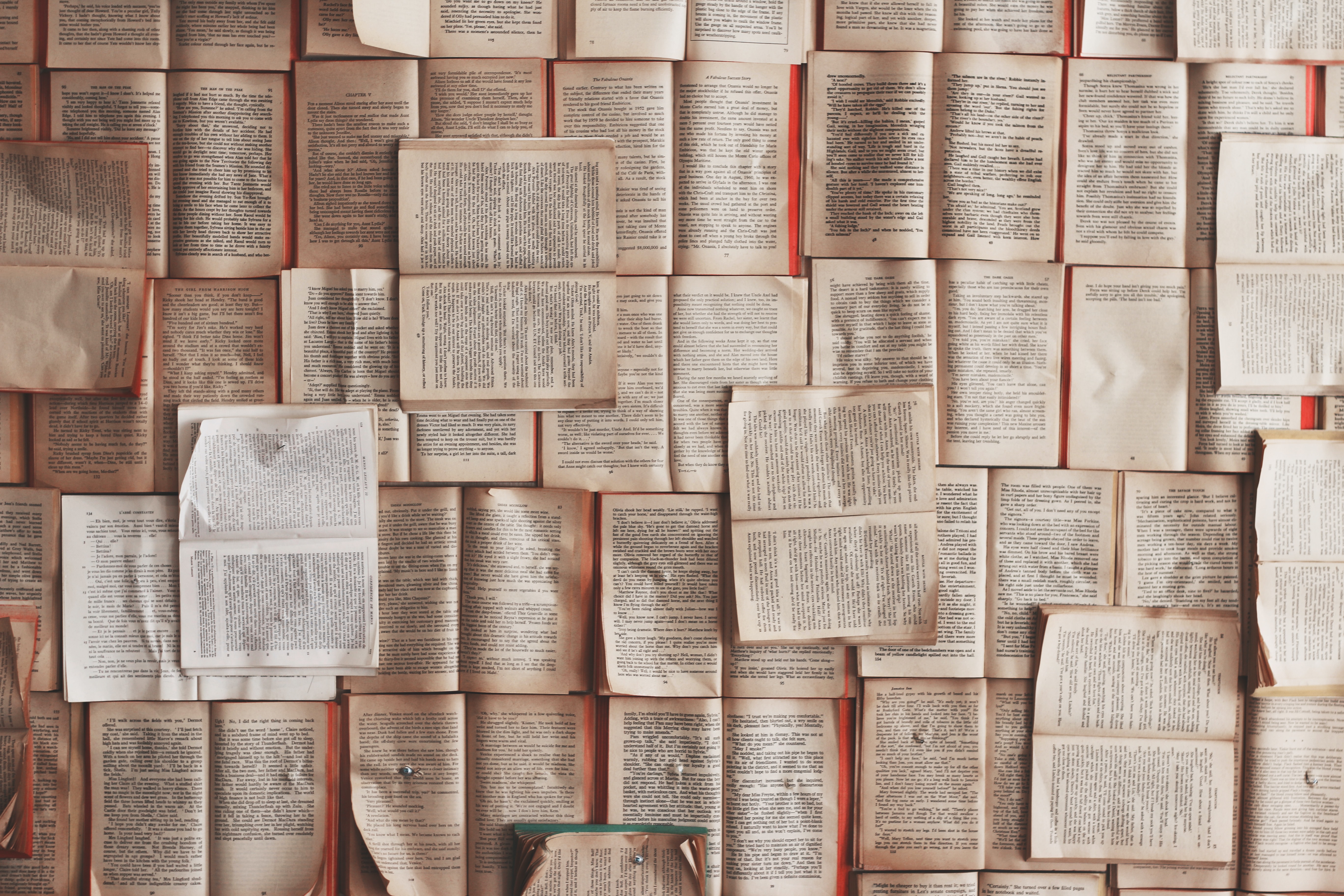 Open books pinned to a wall creating a collage.